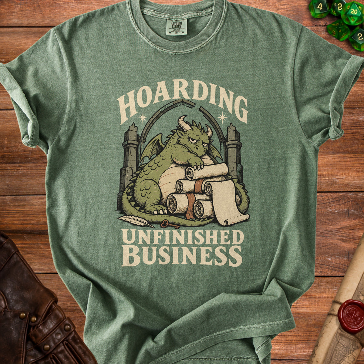Green t-shirt with a dragon hoarding scrolls and the text "HOARDING UNFINISHED BUSINESS".