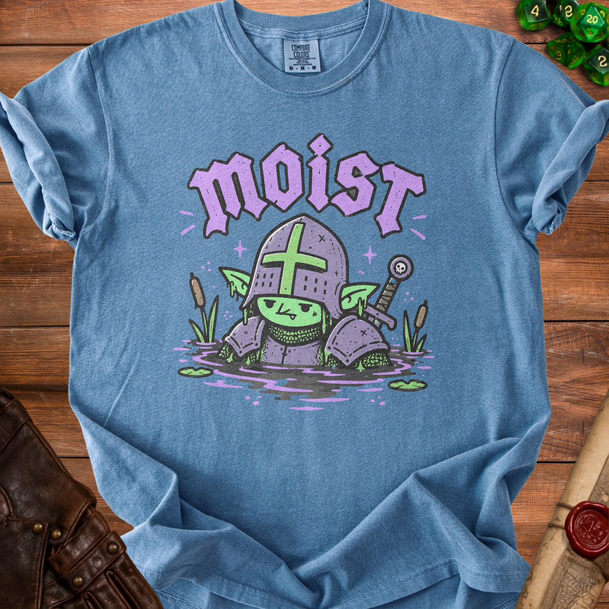 Blue t-shirt with a cartoon goblin knight in swampy water, text reads "moist".