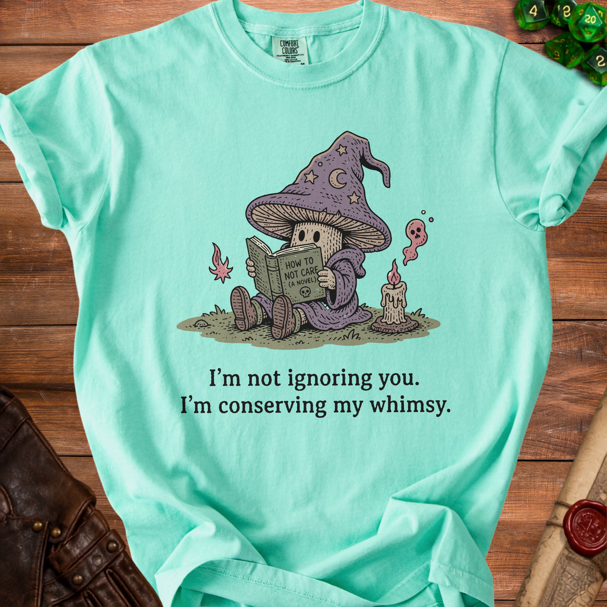 Mint t-shirt with mushroom wizard reading "How to Not Care" and text "I'm conserving my whimsy."