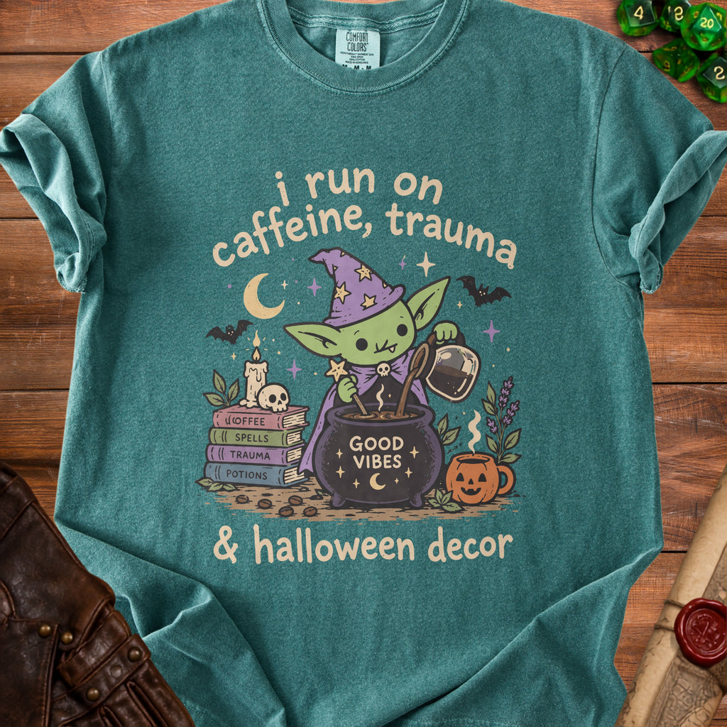 Green t-shirt with "i run on caffeine, trauma & halloween decor" text and goblin graphic.