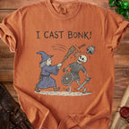 T-shirt with graphic of wizard casting spell on a skeleton and the text "I CAST BONK!".