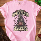 Pink t-shirt with skeleton graphic and text "Out of Spell Slots Still Taking Damage".
