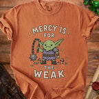 Orange t-shirt with a cartoon goblin holding a flail and the text "Mercy is for the weak".