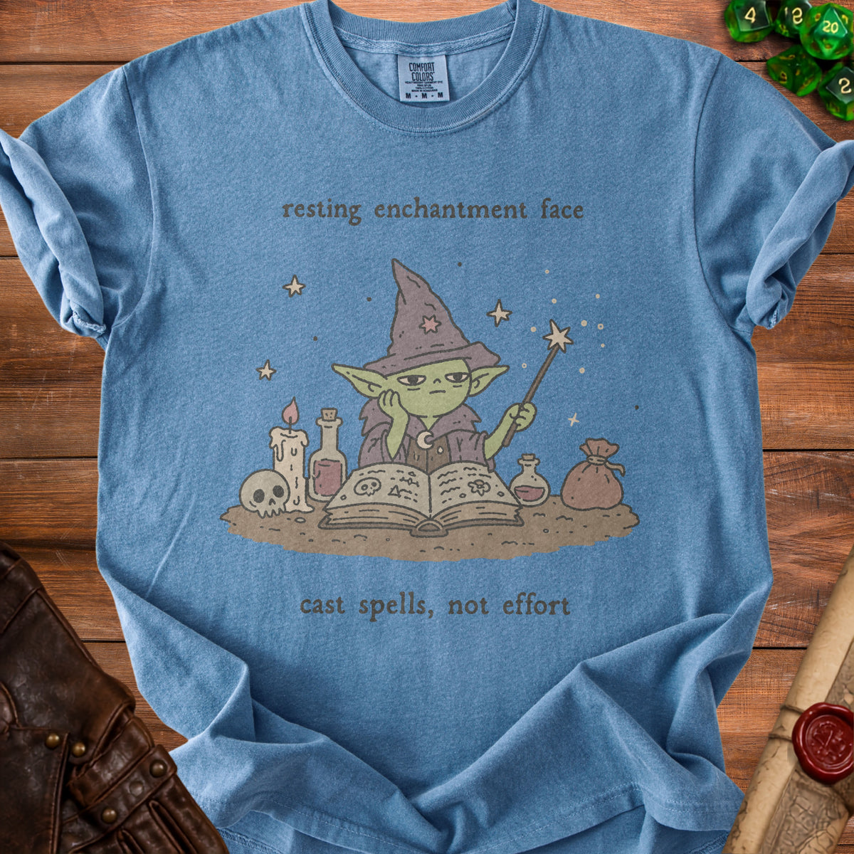 Blue t-shirt with a wizard character and text "resting enchantment face cast spells, not effort".