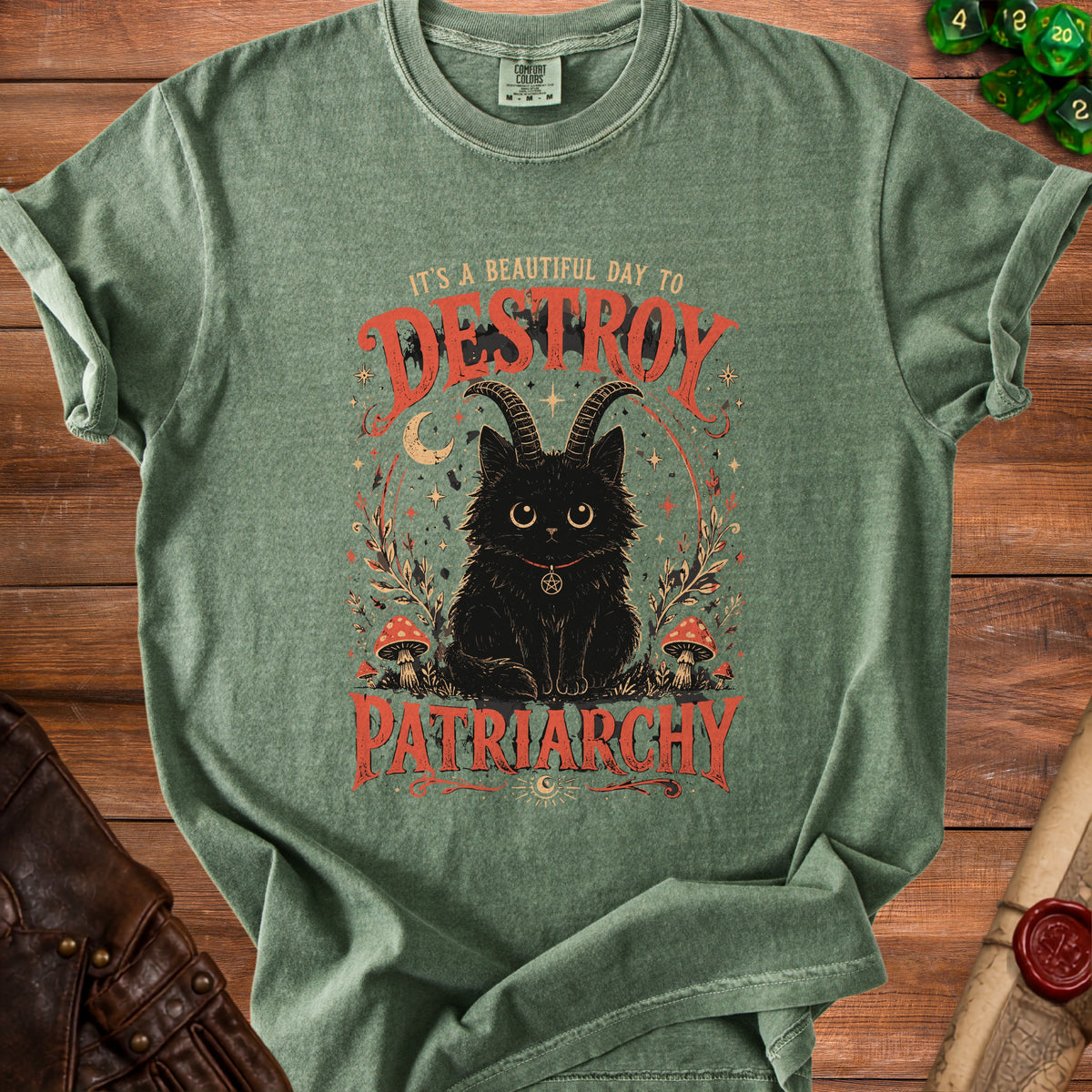 Green t-shirt with graphic of black cat with horns, moons, stars, and text "IT'S A BEAUTIFUL DAY TO DESTROY PATRIARCHY."