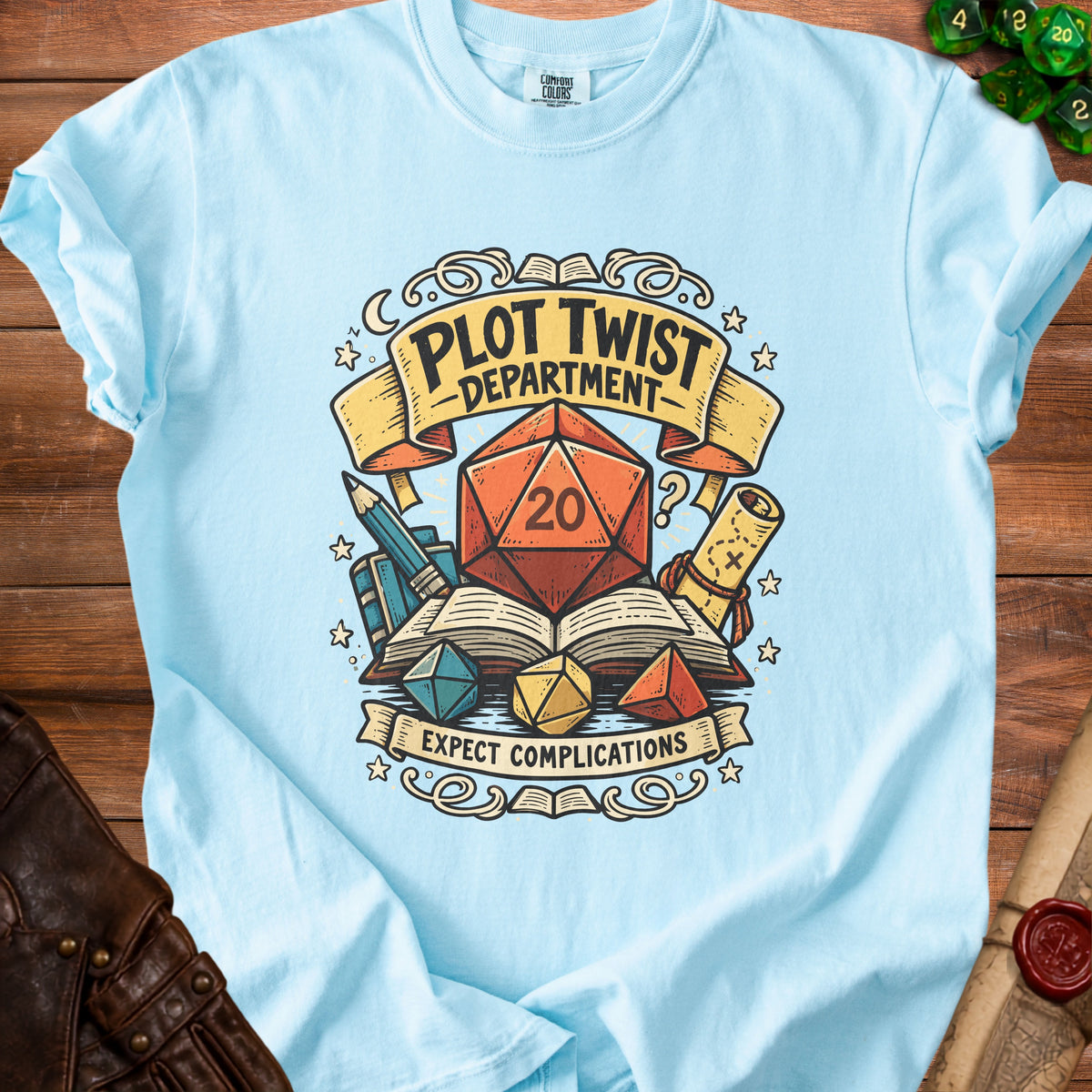 Light blue t-shirt graphic with "Plot Twist Department" and "Expect Complications."