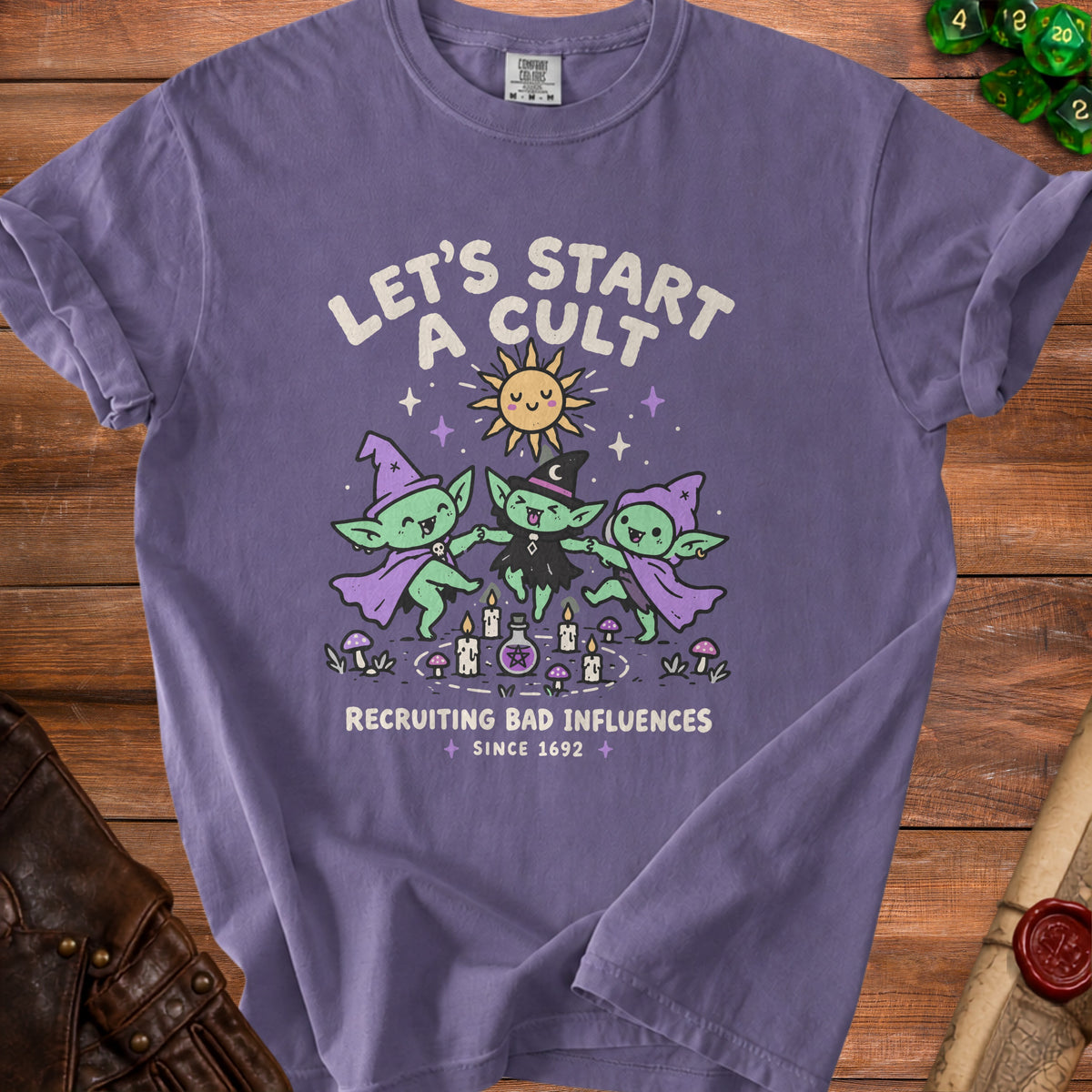 Purple t-shirt with "Let's Start A Cult Recruiting Bad Influences Since 1692" text and cartoon goblins.