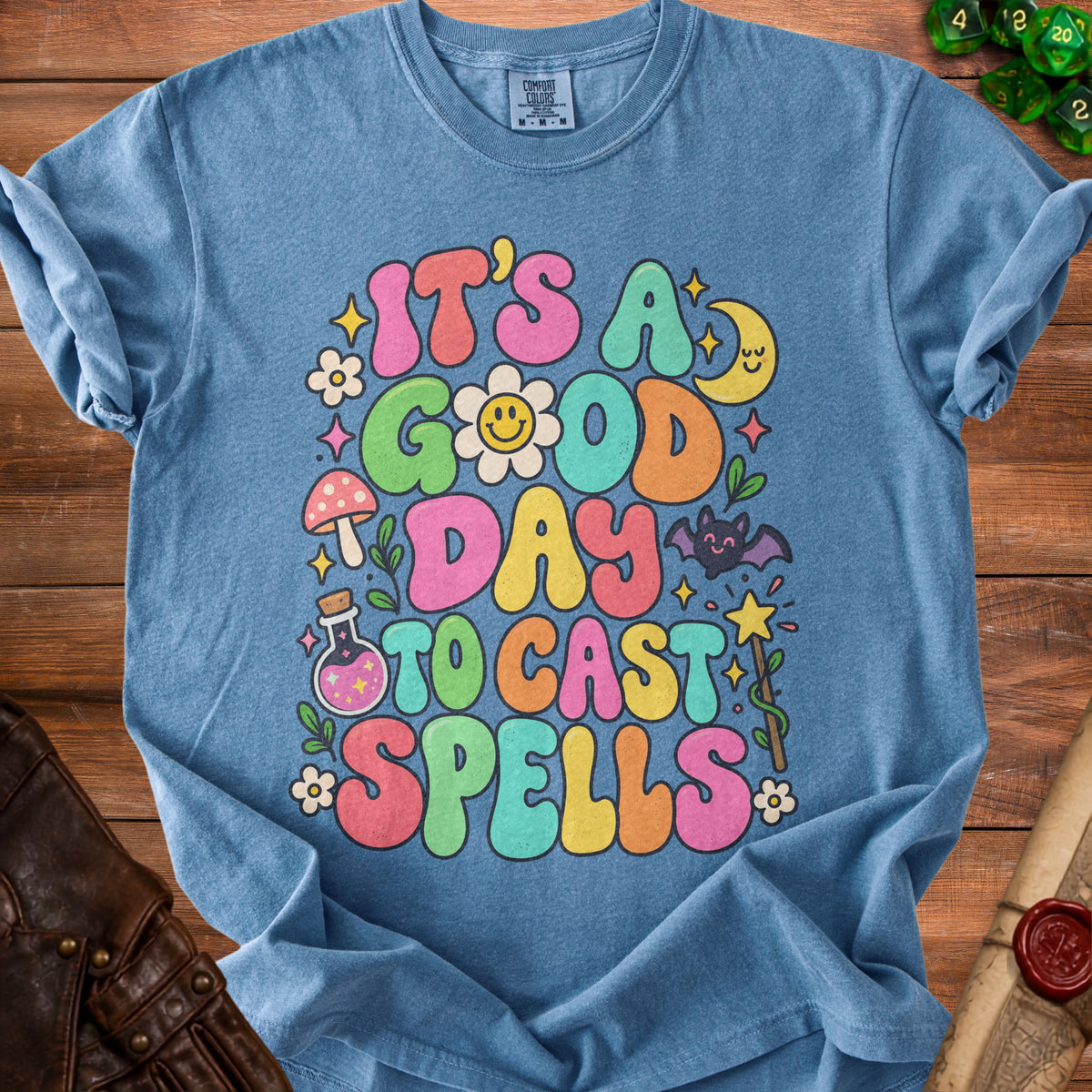 Blue t-shirt with "It's A Good Day To Cast Spells" in colorful bubble letters.