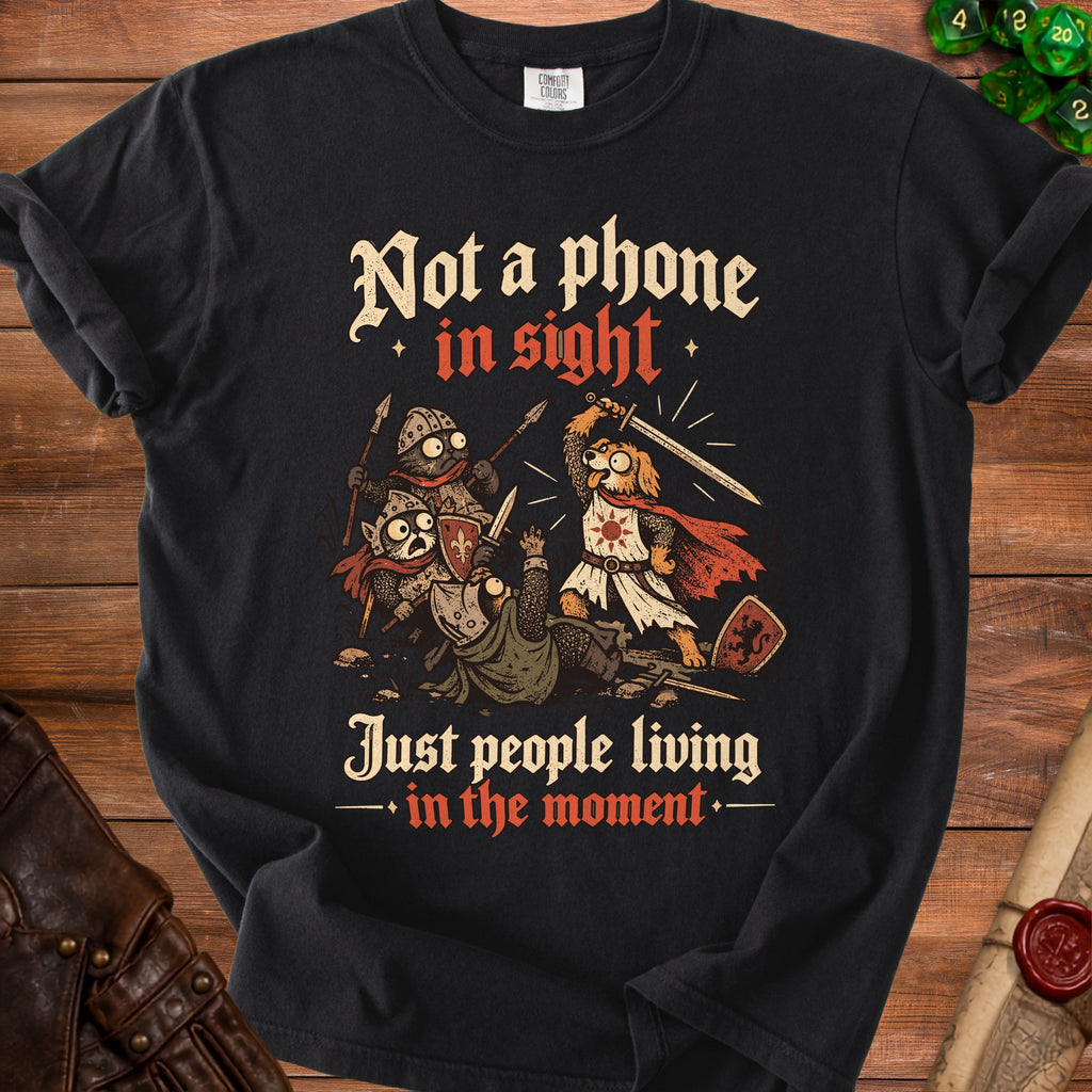 Black t-shirt with medieval cats and dogs fighting, text says "Not a phone in sight. Just people living in the moment."