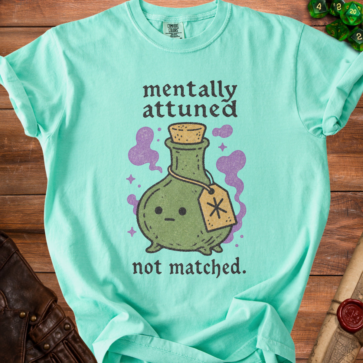Mint green t-shirt with text and potion graphic: "mentally attuned not matched."