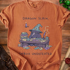 Orange t-shirt with a raven wearing a wizard hat and text "Dragon Slain, Inbox Undefeated".