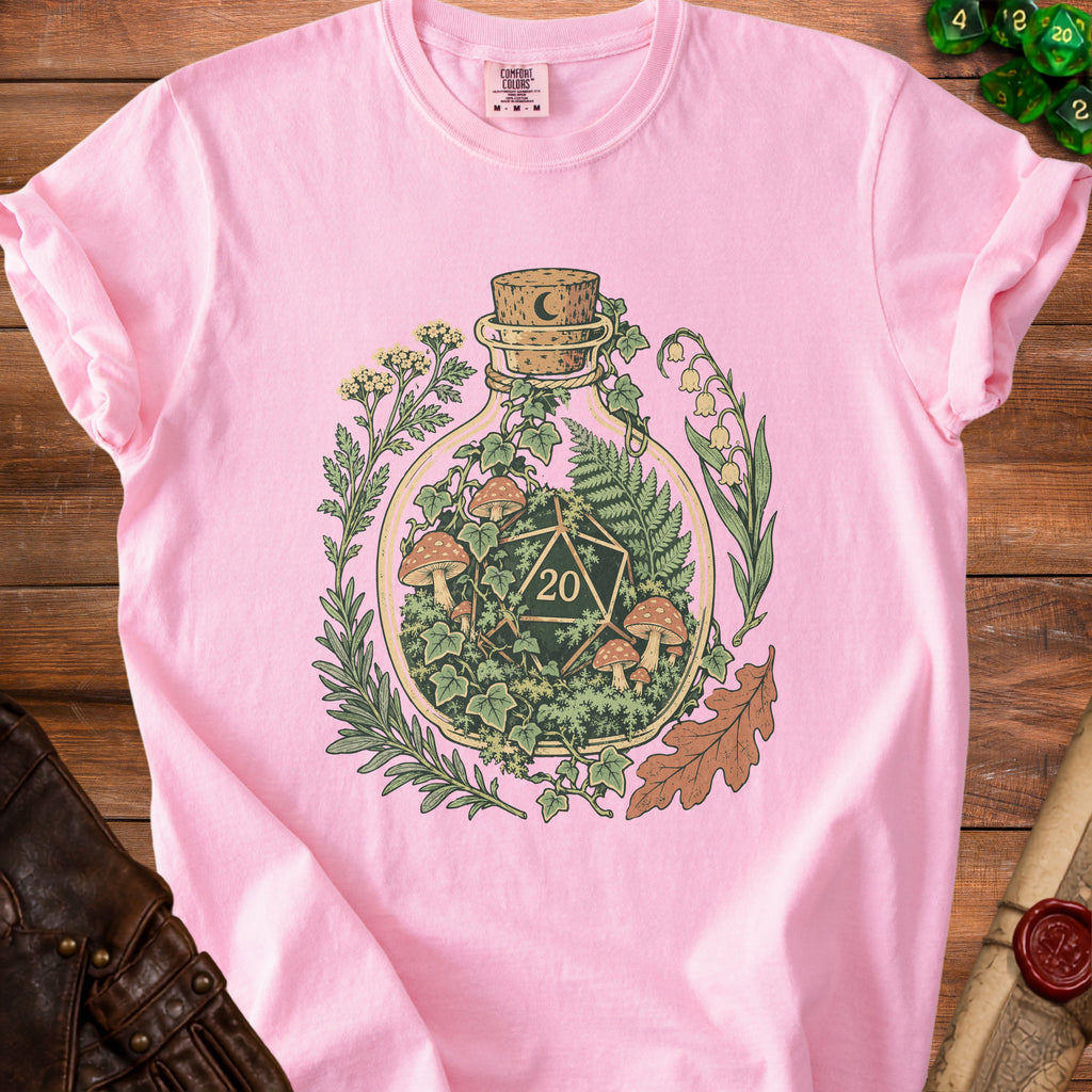 Pink t-shirt with a bottle containing a D20 die and botanical elements.