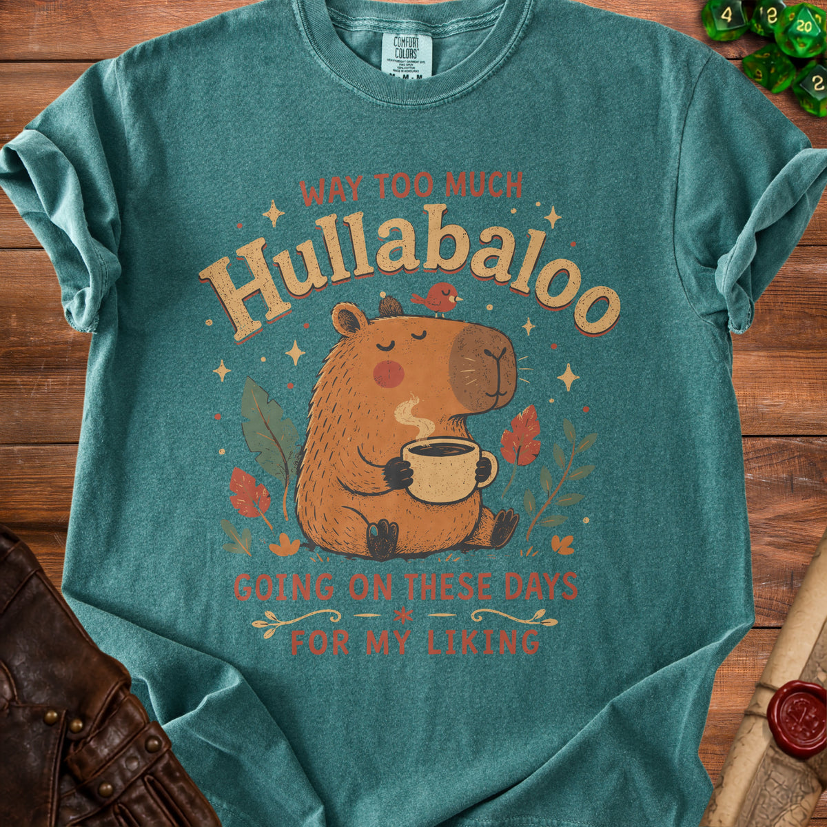Teal t-shirt with capybara drinking coffee, "Hullabaloo" text, and dice.