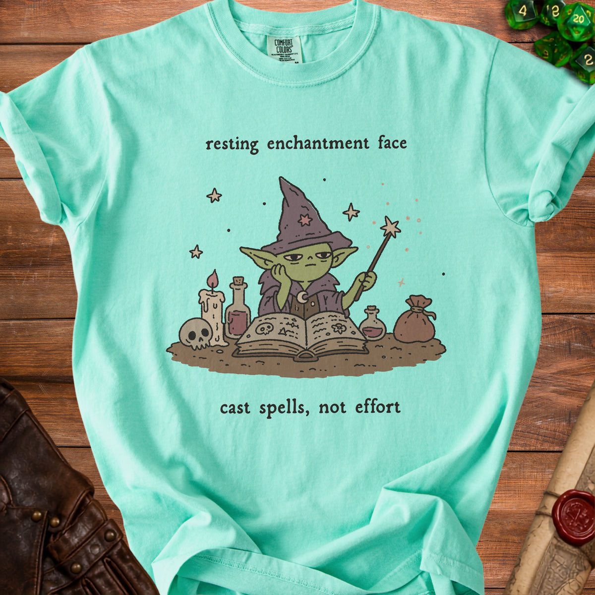 Green t-shirt with a grumpy goblin wizard, book, and potion, stating "resting enchantment face cast spells, not effort."