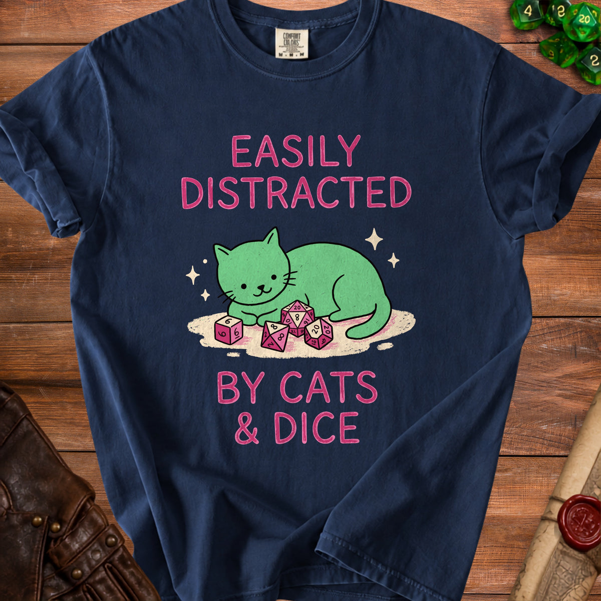 Dark blue t-shirt with pink text "EASILY DISTRACTED BY CATS & DICE" and a green cat graphic.