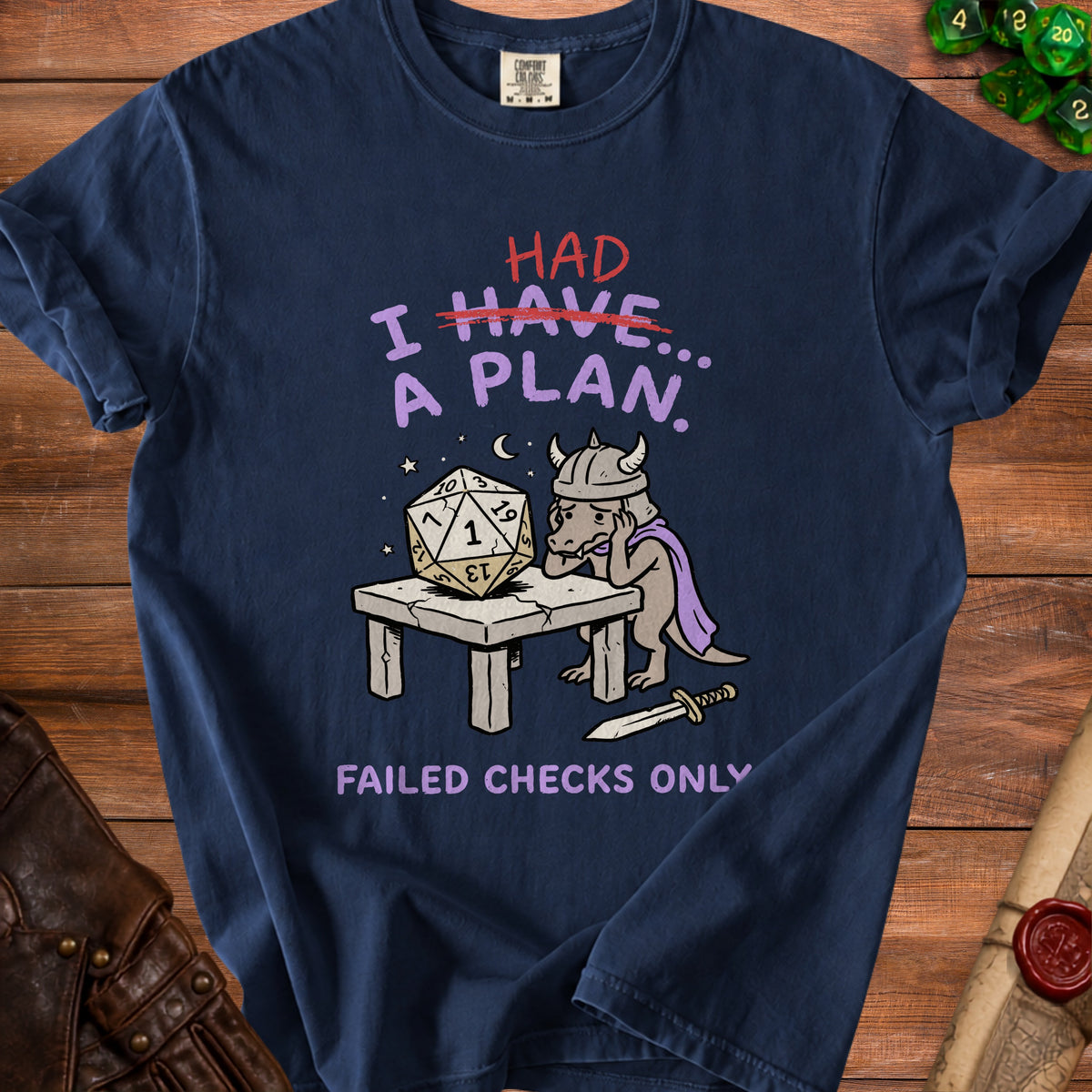 T-shirt with cartoon dragon and dice, reads "I HAVE... A PLAN. FAILED CHECKS ONLY".