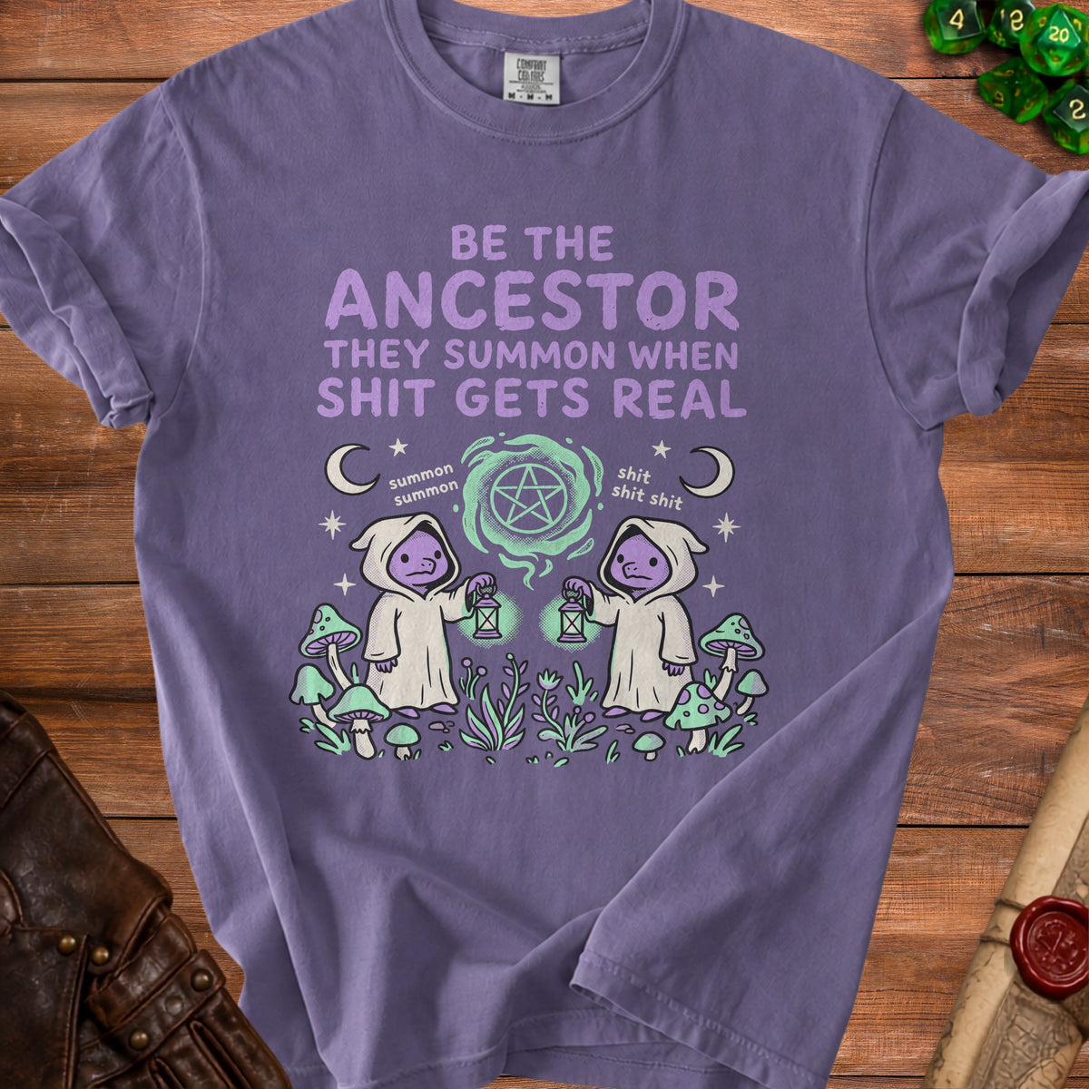Purple t-shirt with "Be the ancestor they summon when shit gets real" text and occult graphics.