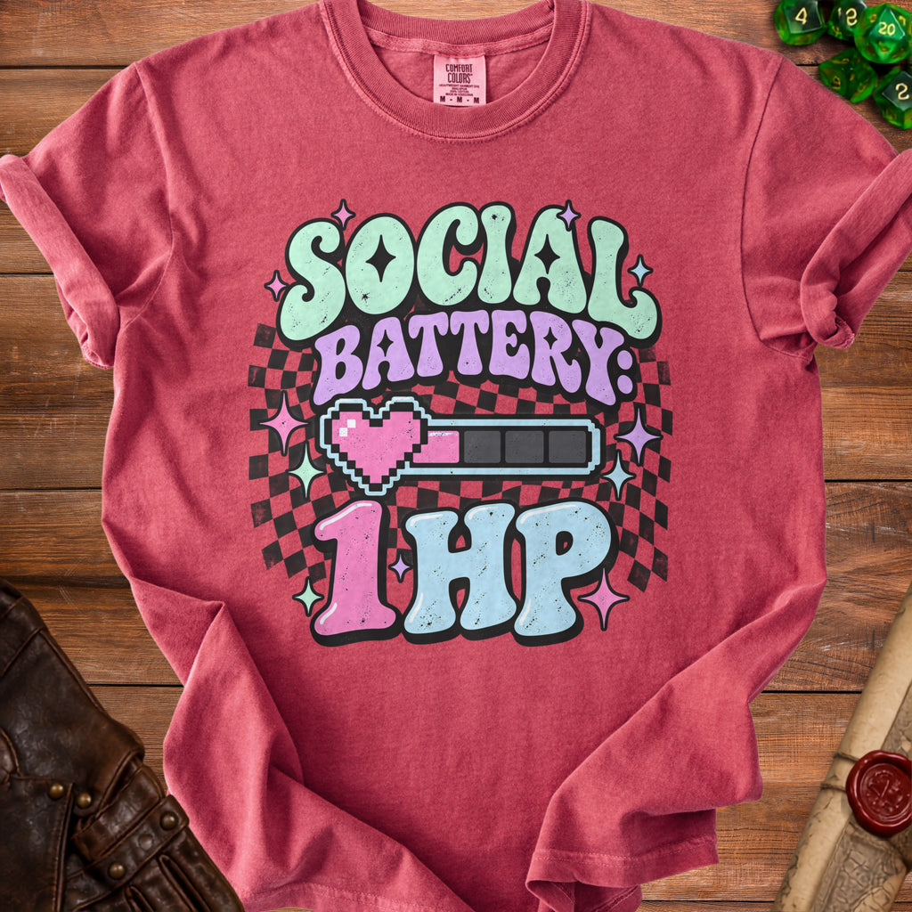 T-shirt with text "SOCIAL BATTERY: 1HP", pixel heart, and battery graphic.