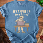 Blue t-shirt with mummy graphic and "WRAPPED UP in chores" text.