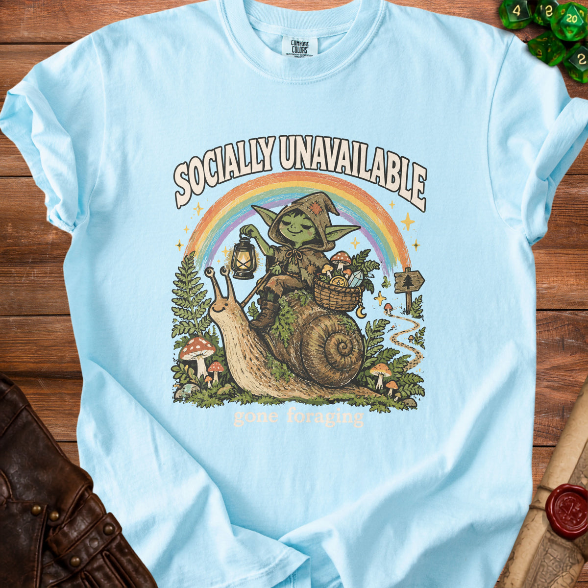 Light blue t-shirt with goblin riding snail, "Socially Unavailable" and "gone foraging" text.