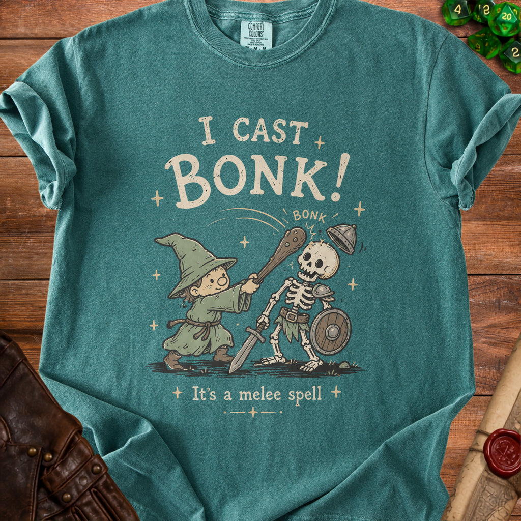Green t-shirt with cartoon of wizard fighting skeleton with text "I cast bonk!"