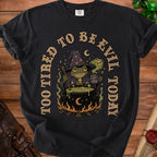 Black t-shirt with a wizard frog stirring a cauldron; "Too Tired to Be Evil Today" text.