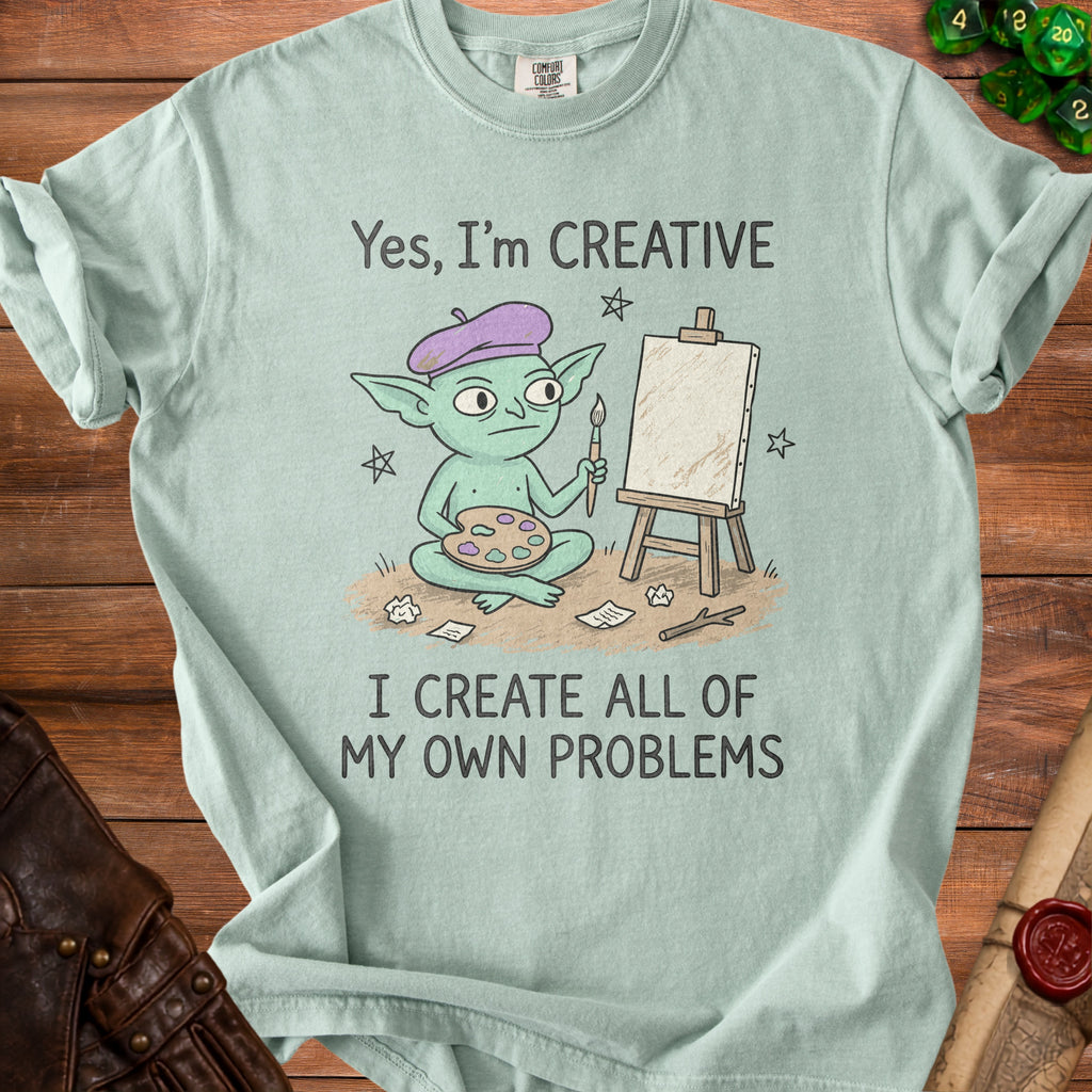 Mint t-shirt with illustration of a goblin artist and text "Yes, I'm CREATIVE I CREATE ALL OF MY OWN PROBLEMS".