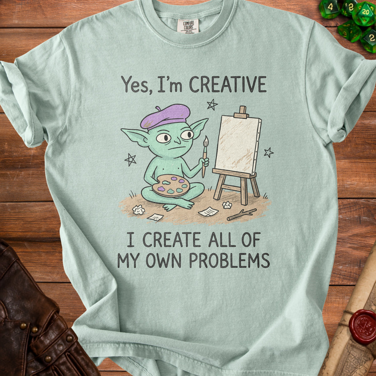 Mint t-shirt with illustration of a goblin artist and text "Yes, I'm CREATIVE I CREATE ALL OF MY OWN PROBLEMS".
