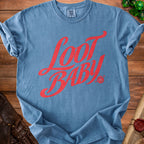 Blue t-shirt with red "Loot Baby" text and a d20 dice graphic.