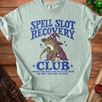 Light blue t-shirt with frog wizard graphic and "Spell Slot Recovery Club" text.