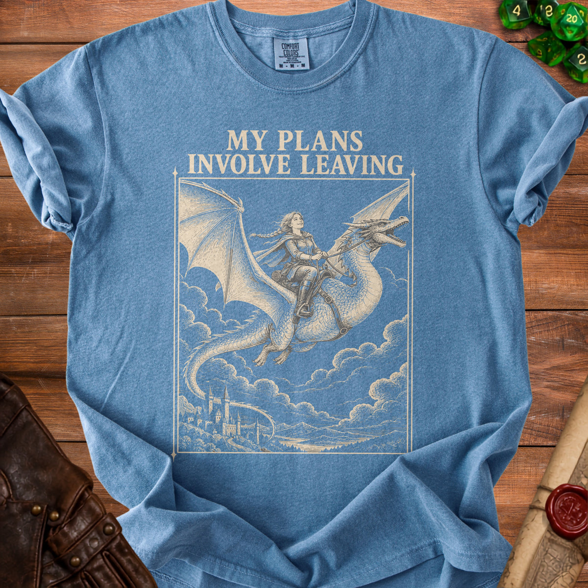 Blue t-shirt featuring a vintage-style graphic of a person riding a flying dragon above a castle.