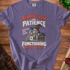 Purple t-shirt graphic: Skeleton with witch hat, coffee, black cat, books, and text.