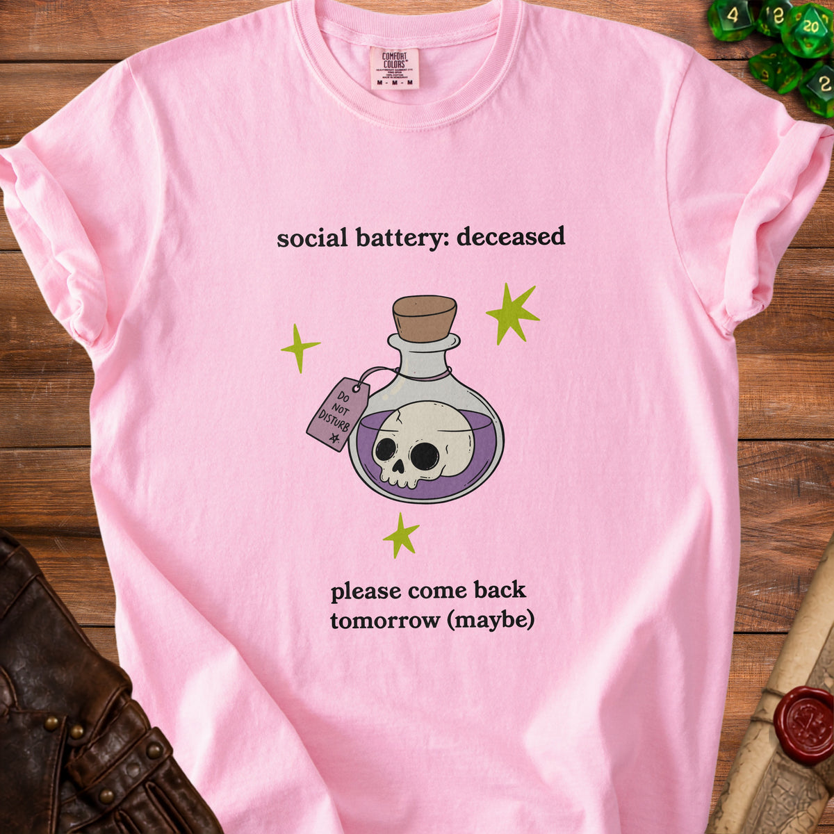 Pink t-shirt with text "social battery: deceased" and skull in a potion bottle.