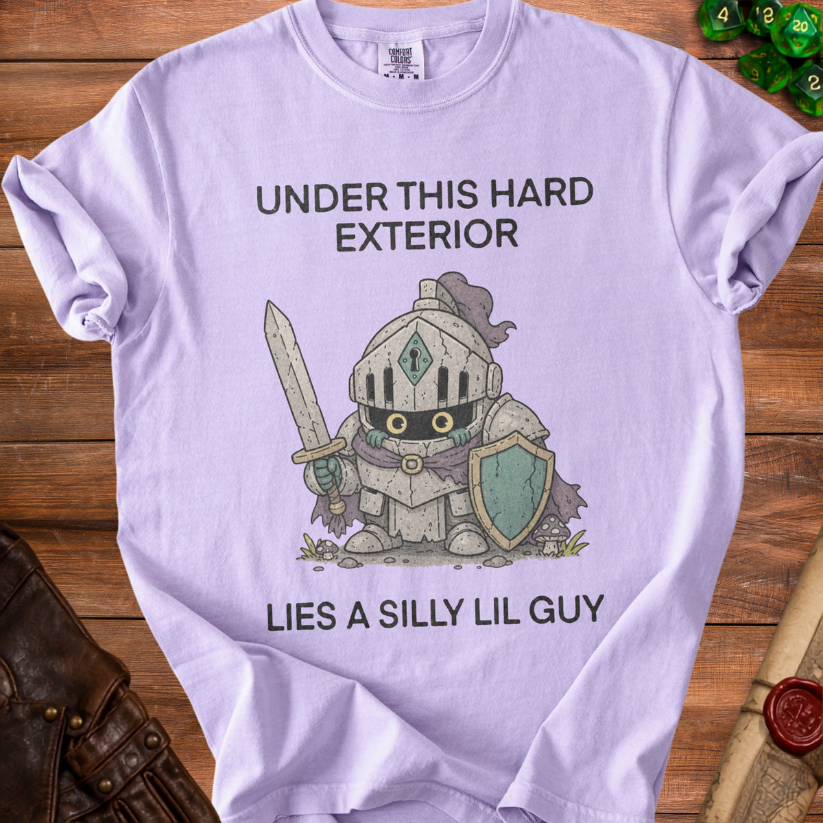 Lavender t-shirt with a knight graphic and the text "UNDER THIS HARD EXTERIOR LIES A SILLY LIL GUY".