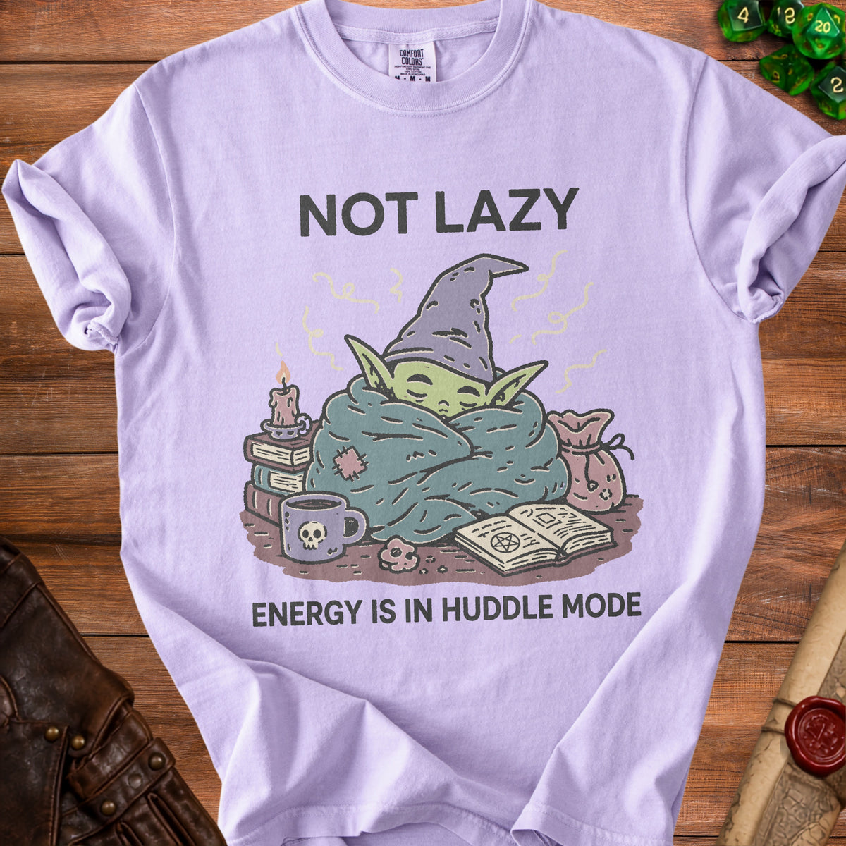 Lilac t-shirt with "NOT LAZY ENERGY IS IN HUDDLE MODE" and wizard baby illustration.