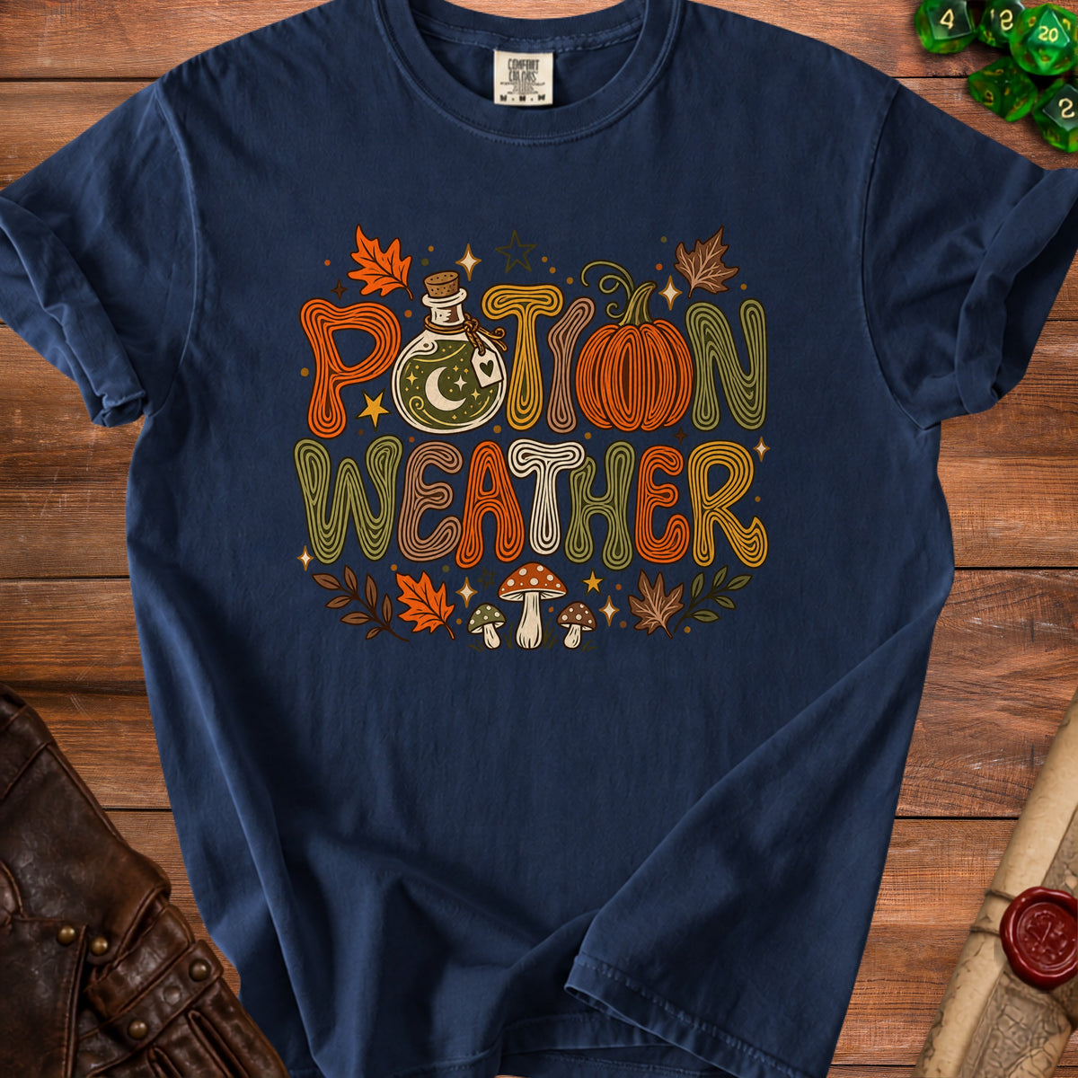 Navy t-shirt with "Potion Weather" graphic featuring a potion bottle, pumpkin, and mushrooms.