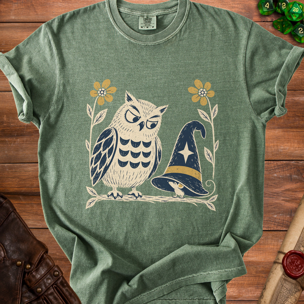 Green t-shirt with an illustrated owl and witch hat design.