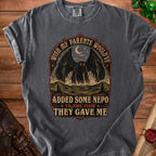 Dark gray t-shirt with "Wish my parents would've added some nepo to the tism they gave me" text and mothman graphic.