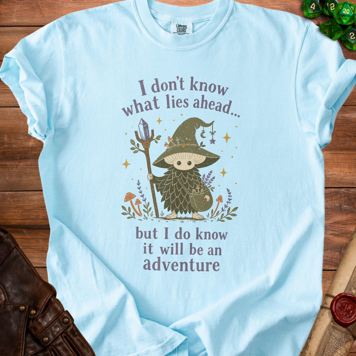 Light blue t-shirt with illustration of a mushroom wizard and text.