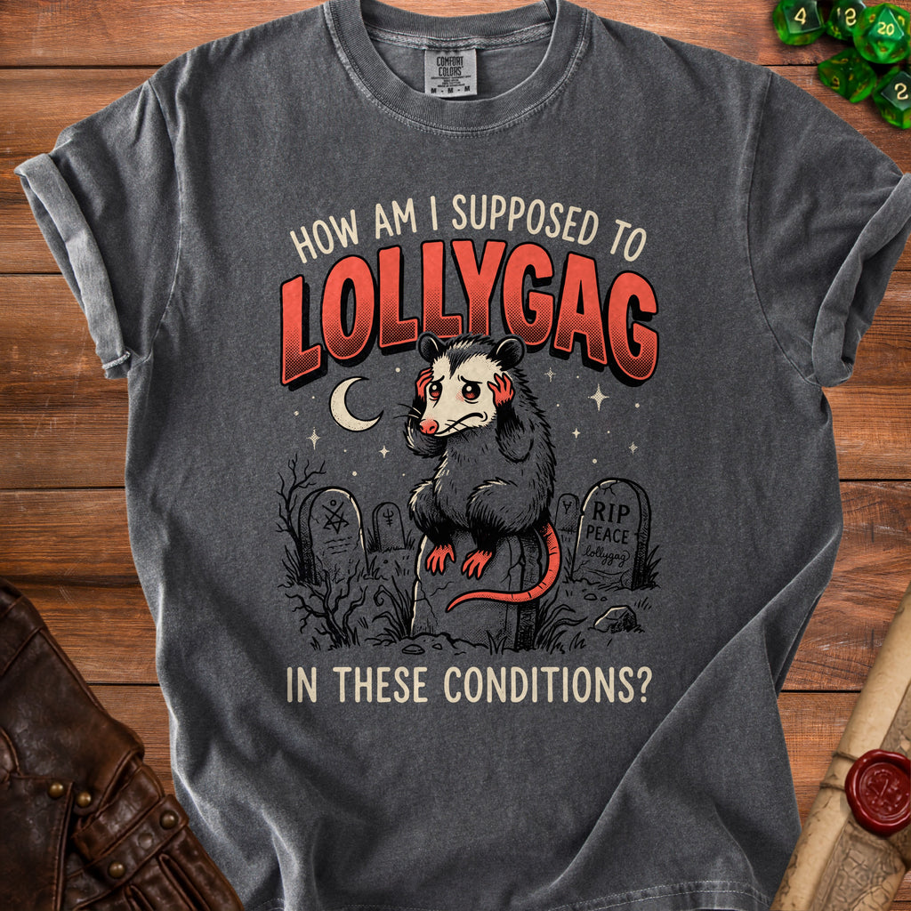 Dark grey t-shirt with a distressed graphic of a possum in a graveyard and text "How am I supposed to lollygag in these conditions?".