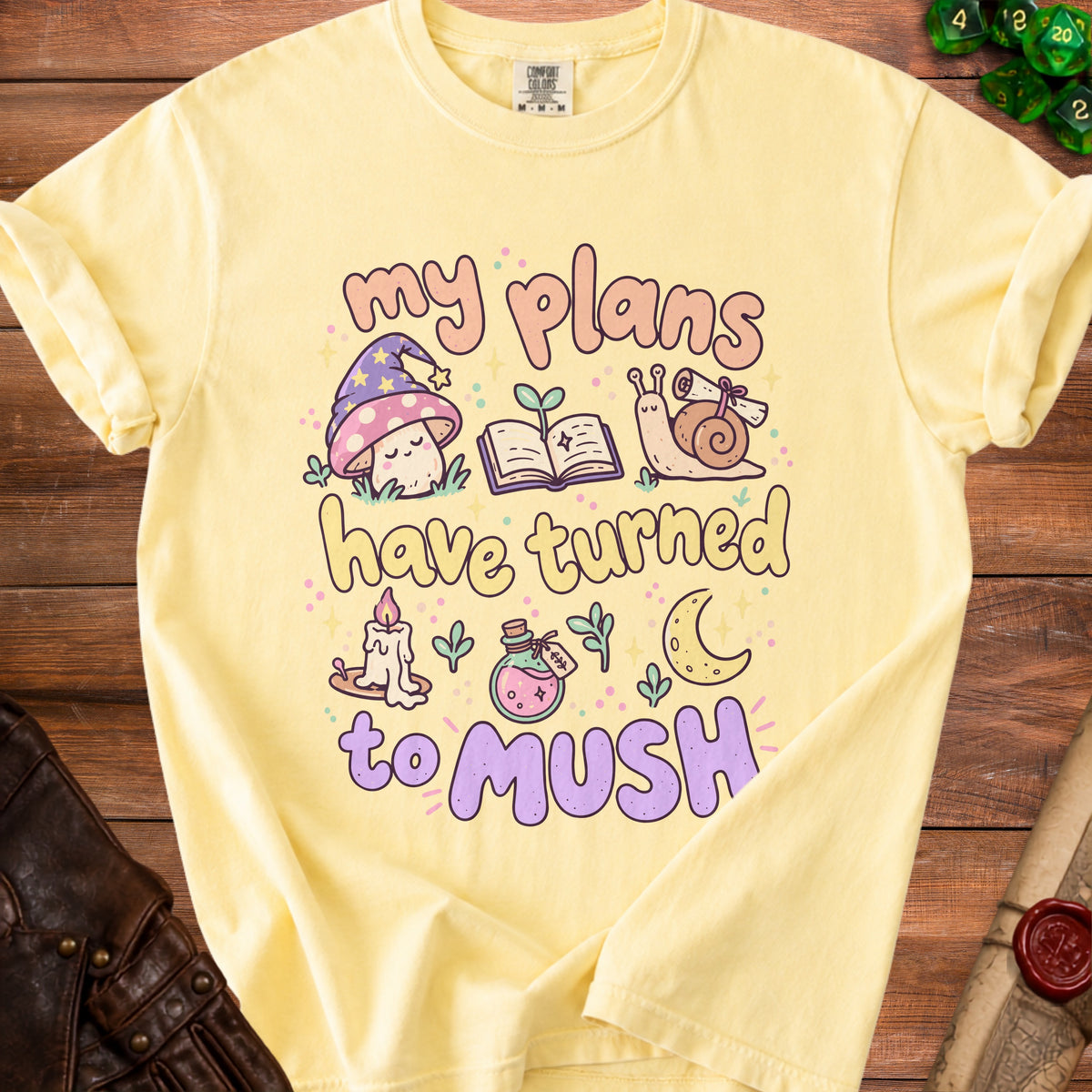 Yellow t-shirt with "my plans have turned to mush" text and whimsical illustrations.
