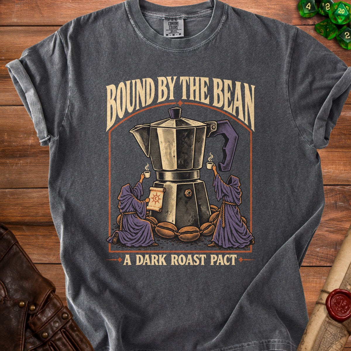 T-shirt with graphic of moka pot, robed figures, coffee beans, and text "BOUND BY THE BEAN A DARK ROAST PACT".