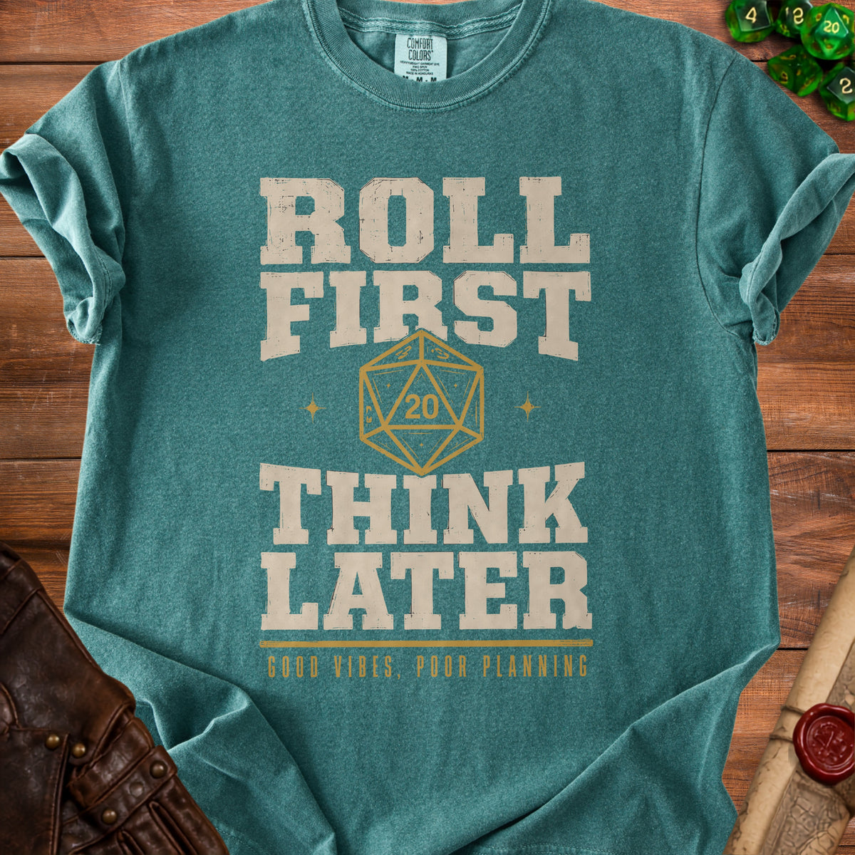 Teal t-shirt with "Roll First Think Later" text and a twenty-sided die.