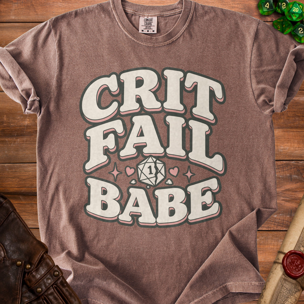 Brown t-shirt with "Crit Fail Babe" text and cracked d20 dice graphic.