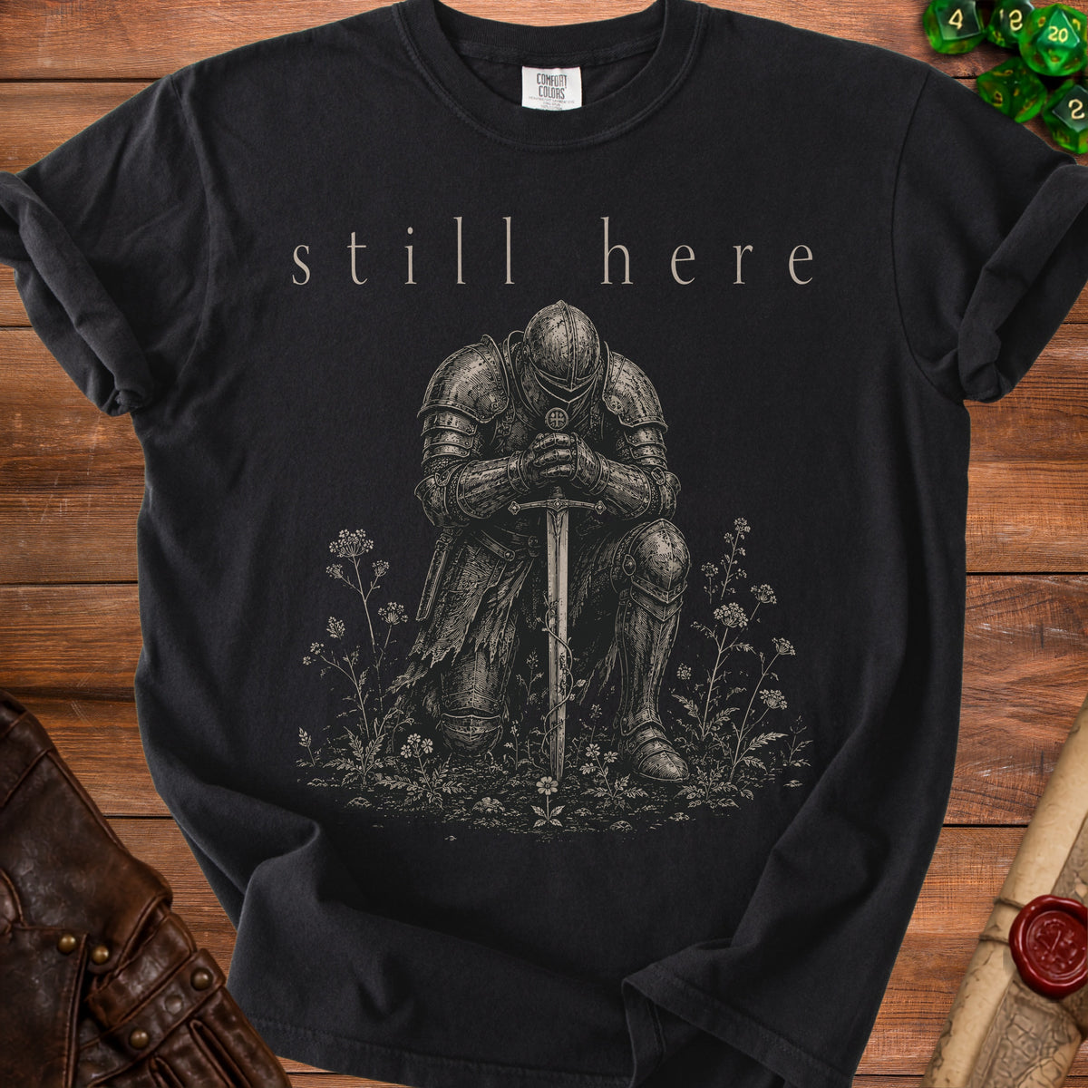 Black t-shirt with kneeling knight and "still here" text.