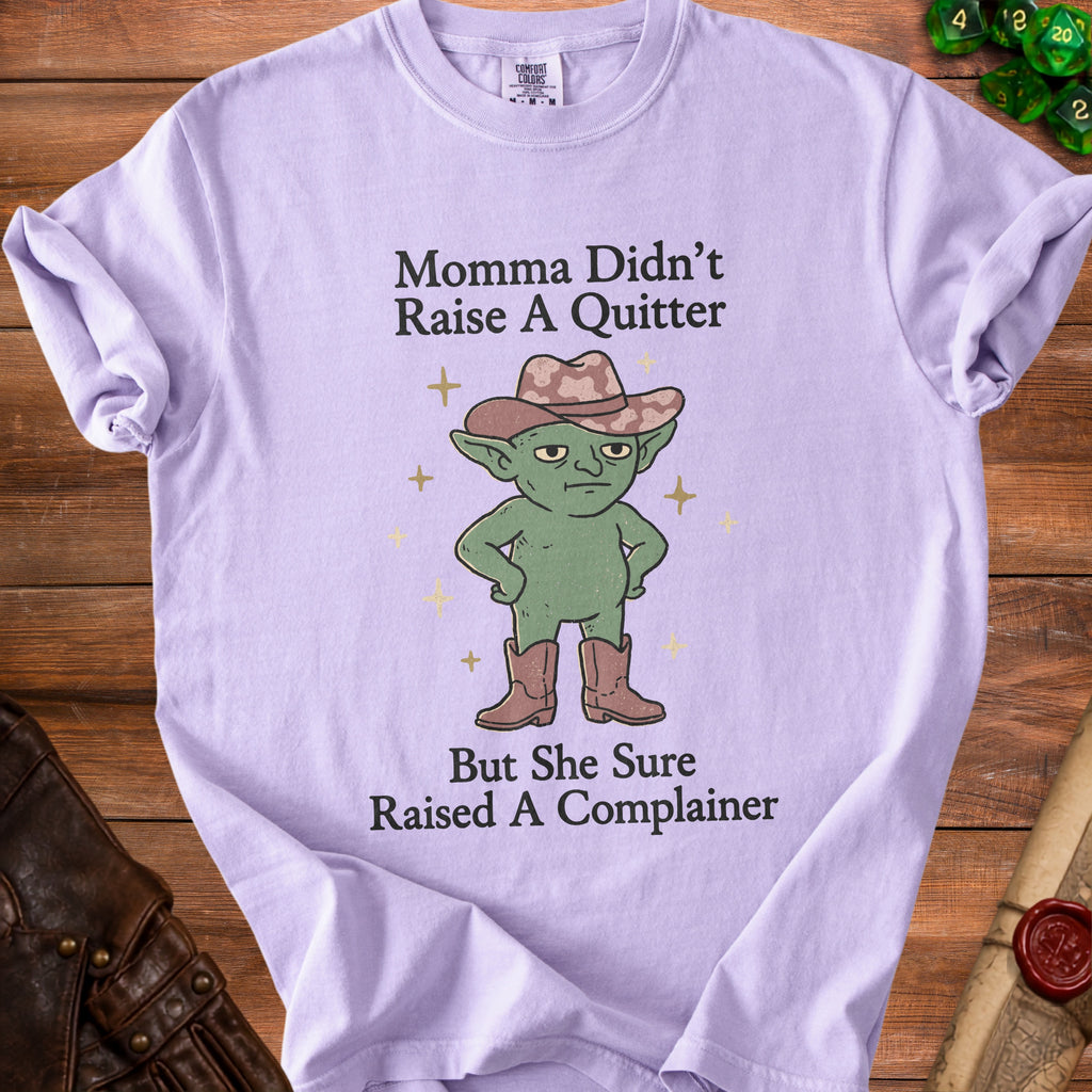 Lilac t-shirt with text "Momma Didn't Raise A Quitter But She Sure Raised A Complainer" and goblin graphic.