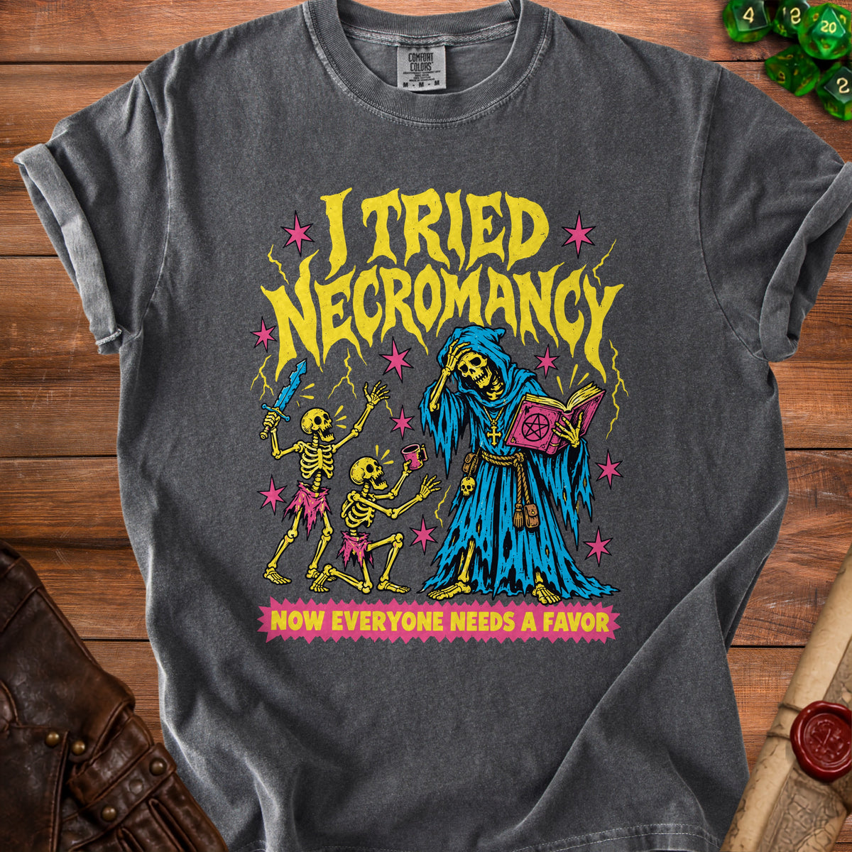 Dark grey t-shirt with "I tried necromancy, now everyone needs a favor" graphic.