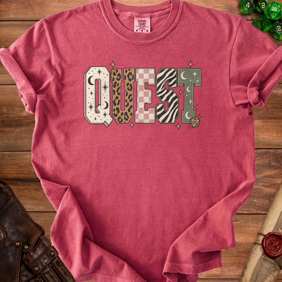Red t-shirt with "QUEST" text in patterned blocks and dice graphics.