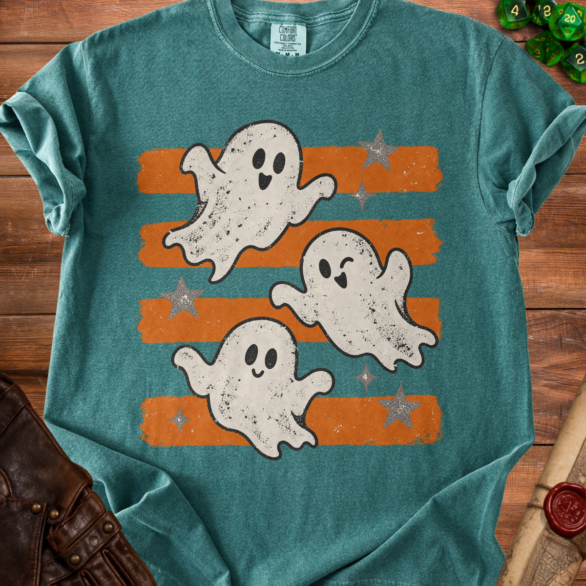 Teal t-shirt with distressed graphic of three playful ghosts on orange and teal stripes.