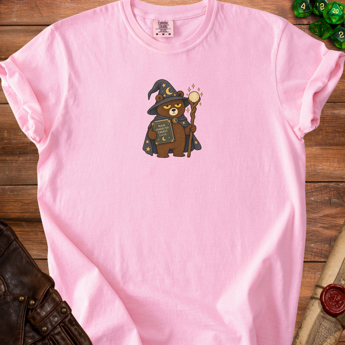 Pink t-shirt with a wizard bear graphic holding a book titled "Main Character Energy (Later)".